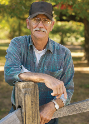 Charlie Gray leaning on a fence.